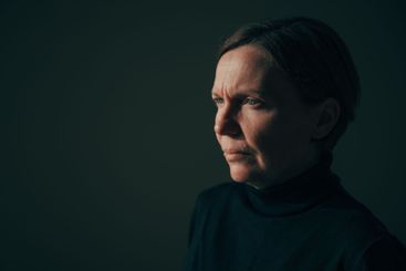 Low key image of serious mature adult brunette female,...