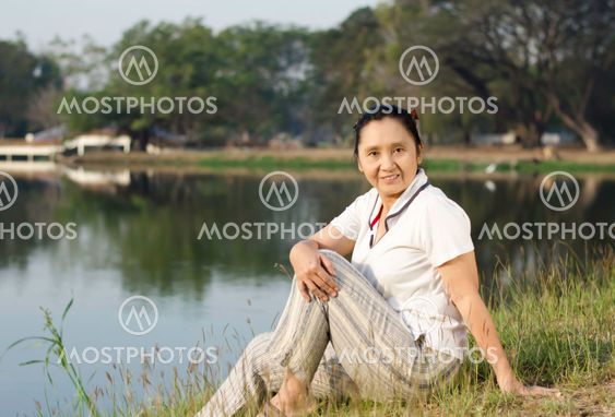 Portrait of smiling woman sitting on green field