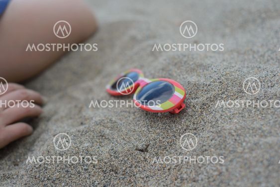 Striped sunglasses in the sand