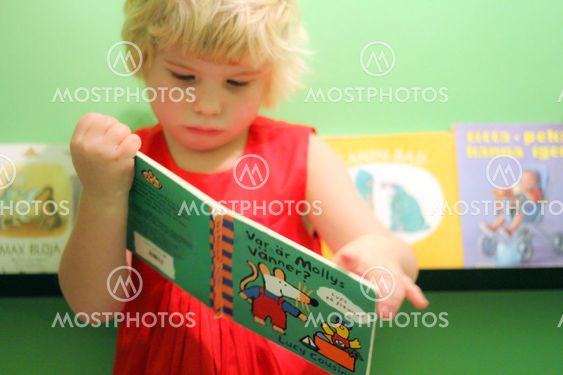 Liten flicka bläddrar i barnbok 1