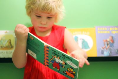 Liten flicka bläddrar i barnbok 1