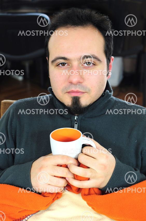 Man in blanket holding cup of tea