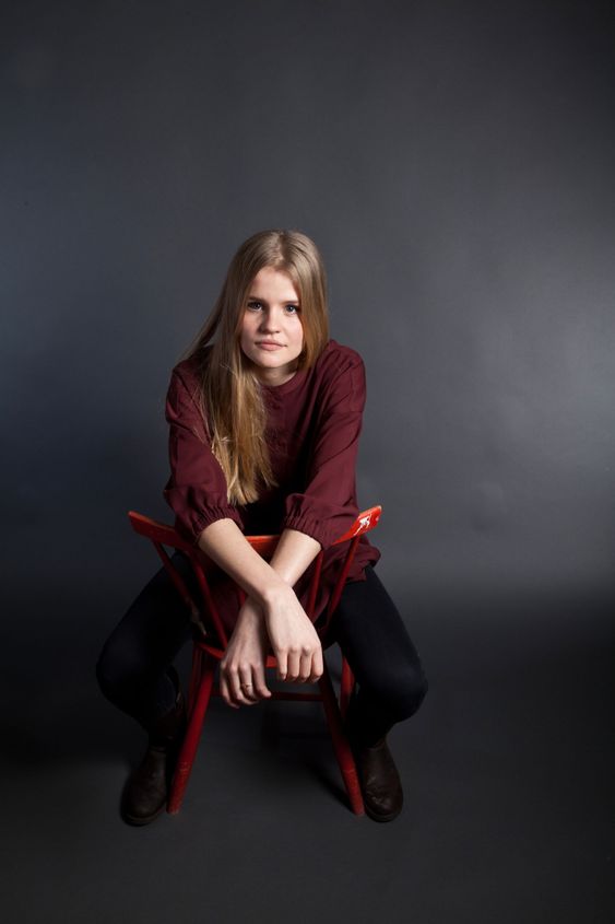 Scandinavian cute young girl sitting on a chair