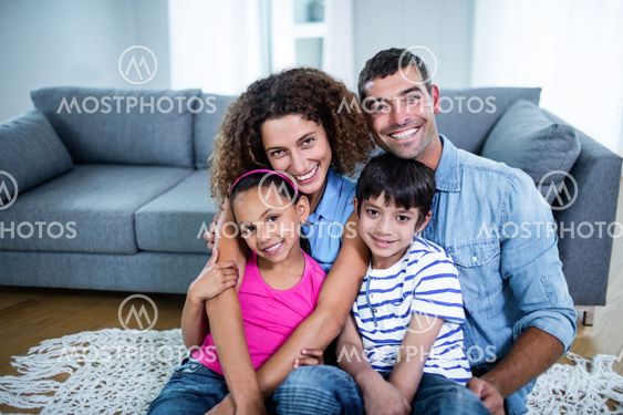 Portrait of happy family sitting together on floor