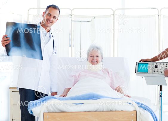A patient with a neck brace looking at an x-ray with her doctor