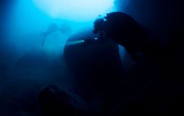 scuba diver diving into the water with a light on