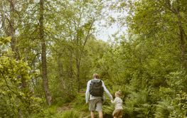 Father and daughter hiking on trail
