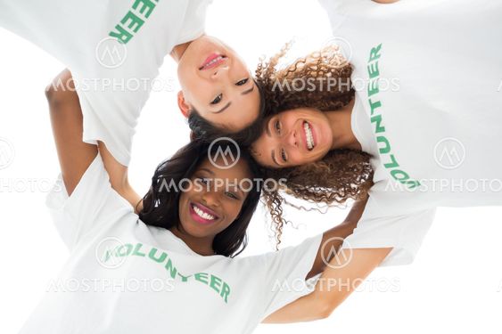 Team of happy volunteers embracing and looking down at camera