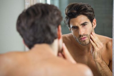 Man checking his stubble in bathroom