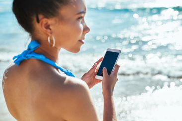 Woman, phone and screen vacation by sea, typing and...