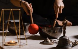 Practicing sound healing with singing bowls during a...