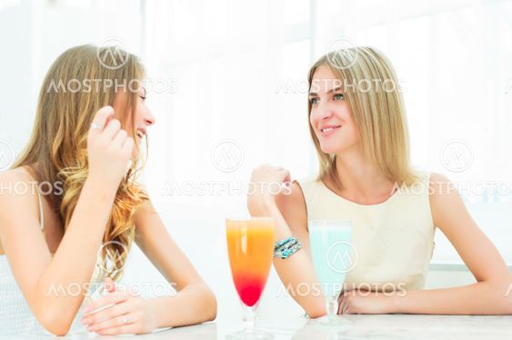 two beautiful women chatting in a cafe