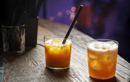 Whiskey sour cocktail on a wooden bar counter in a pub.