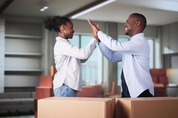 Happy Young Couple Moving Boxes