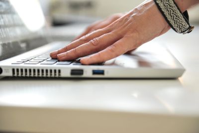 close up female hands on lap top computer