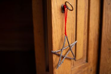 Handmade star ornament of twigs hanging on wooden door...