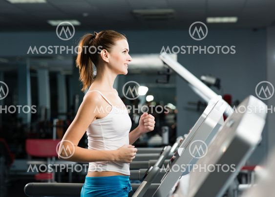 attractive young woman runs on a treadmill