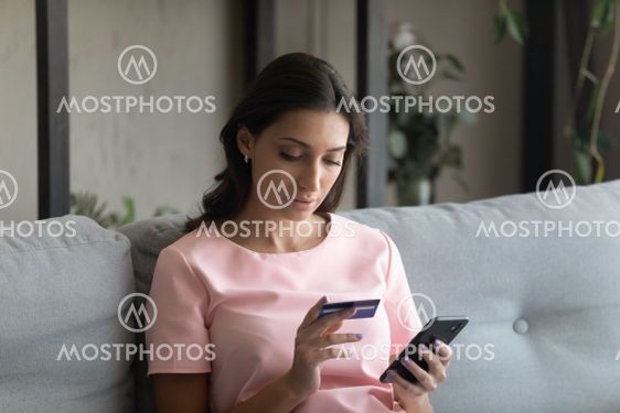 Close up focused Arabian woman holding credit card and...