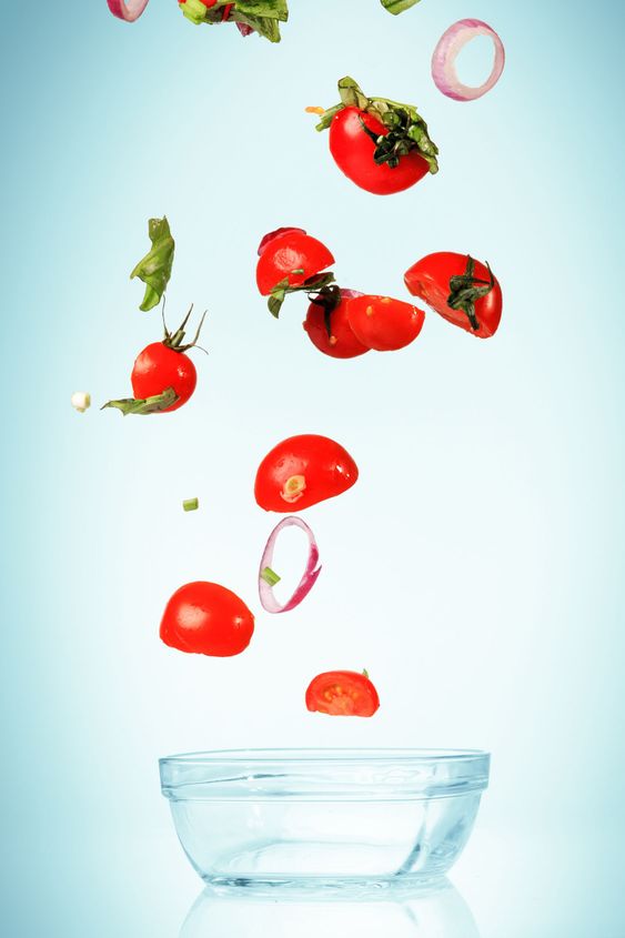 The vegetables for salad falling on blue