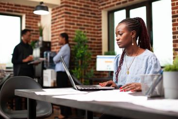 Female manager using laptop in office