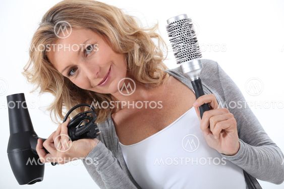 Woman holding a hair dryer and brush