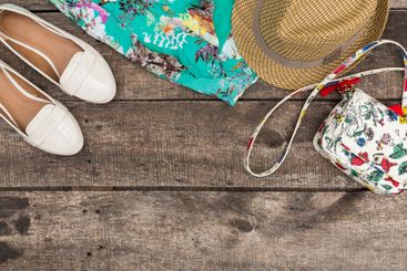 Summer fashion accessories arranged on wooden surface...