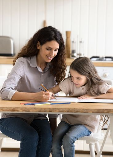 Happy millennial mother young daughter painting pictures...