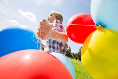 Boy With Colorful Balloons Running In Park
