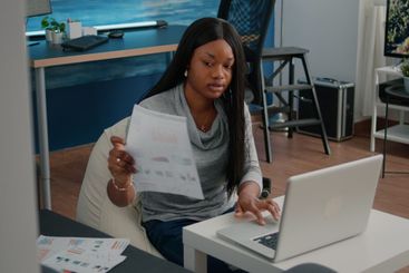 African american student working remote from home at...
