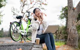Asian woman is immersed in the music playing in her...