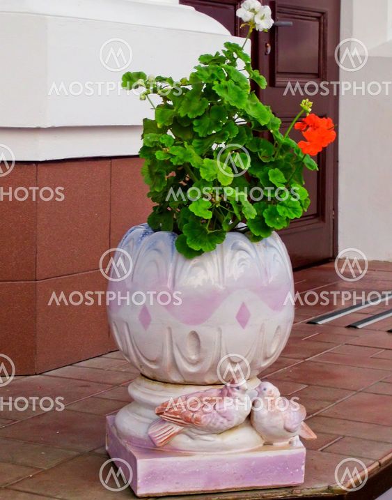 Flowers in a pot and figures of two doves
