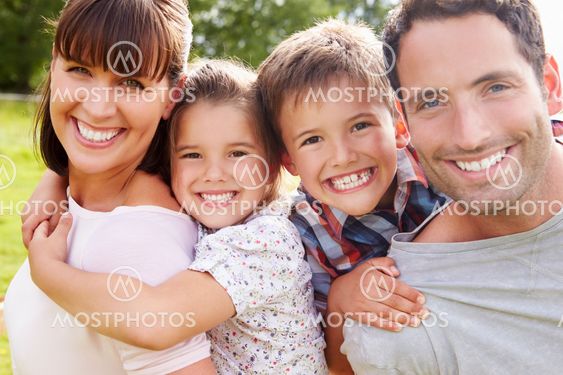 Parents Giving Children Piggybacks Outdoors