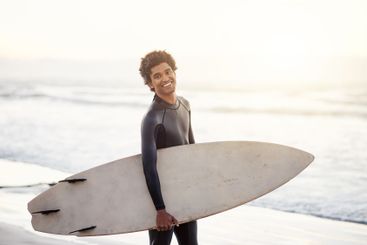 Smile, surfboard or man portrait at sea for fitness...