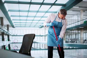 Male Janitor Cleaning Floor With Mop