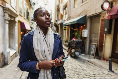 Young african woman walks alone on europe street