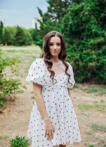 Beautiful brunette woman in summer dress walking in the...