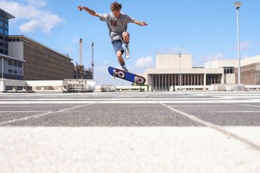Man, jump or air with skateboard in city for parkour...