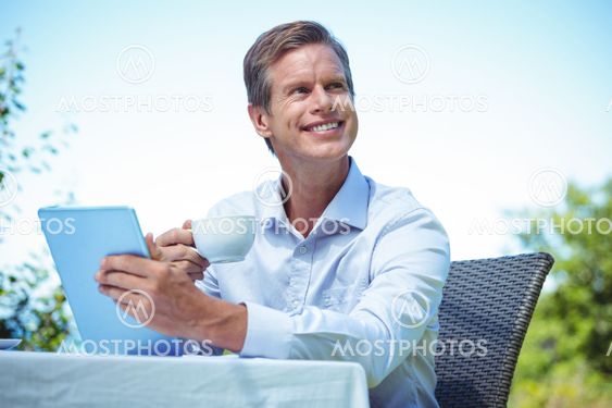 Businessman using tablet with coffee