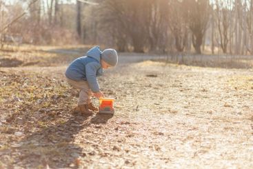 Happy baby child outdoor. Little toddler boy with toy...