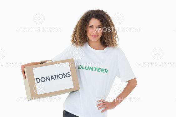 Happy volunteer holding a box of donations with hand on hip