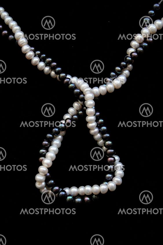 White and black pearls on a black velvet background
