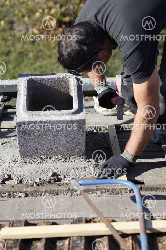 Man adjusting cinder block placement