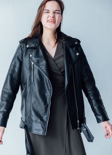 Beautiful slender woman in green summer wincing displeased