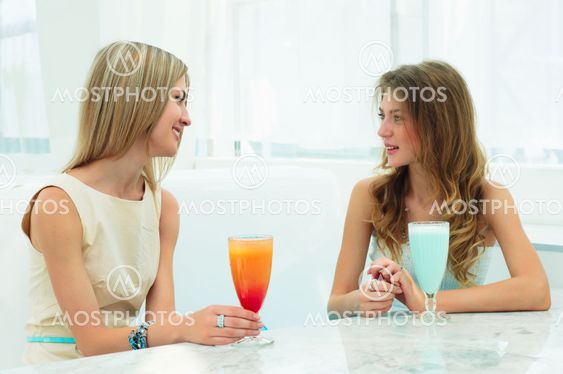two beautiful women chatting in a cafe