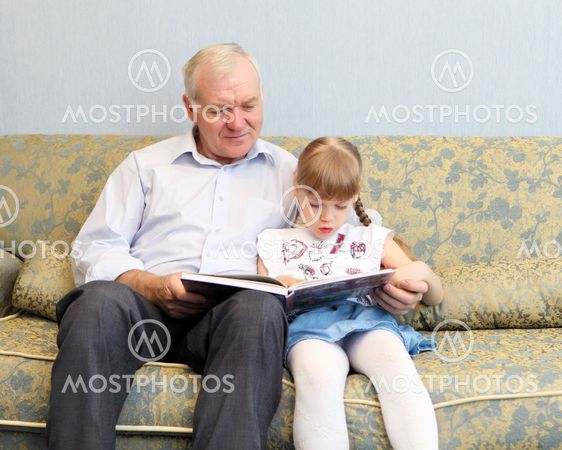 grandfather and granddaughter reading book