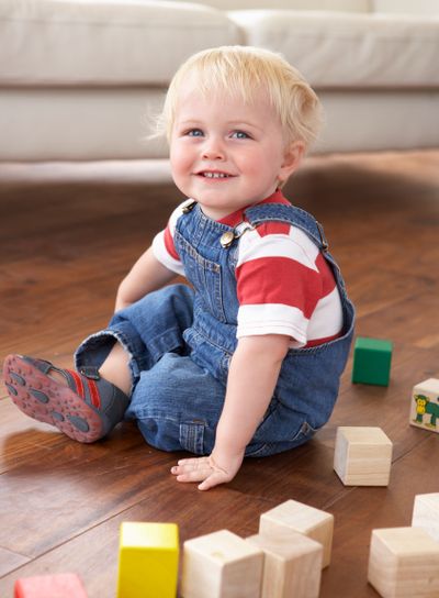 Young Boy Playing With Coloured Blocks At Home