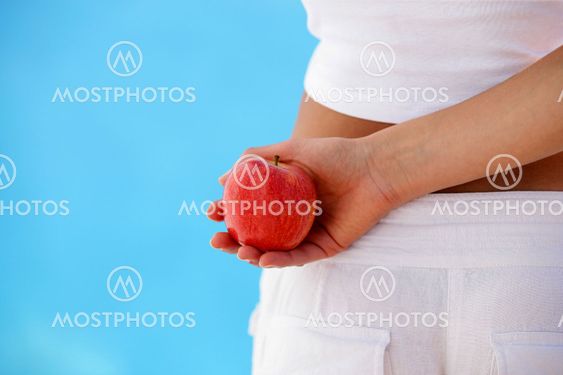 Woman holding an apple behind her back