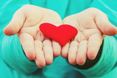 The heart is in the hands of the child. Selective focus.