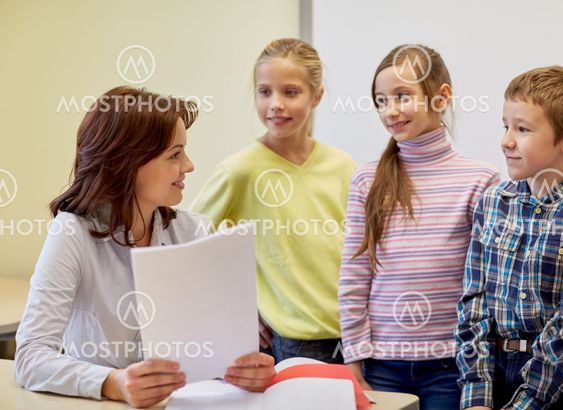 group of school kids with teacher in classroom