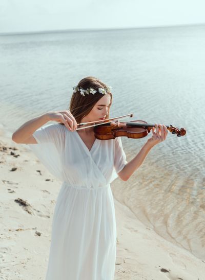 beautiful woman in elegant white dress and floral wreath...